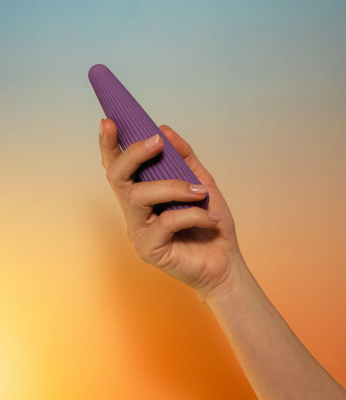 Labas Cyra ergonomic pleasure massager held in hand to show its elegant curved design and premium silicone texture for targeted stimulation.